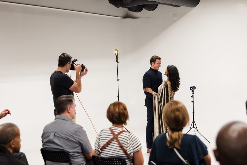 A photographer demonstrating a shot to a seated workshop audience.